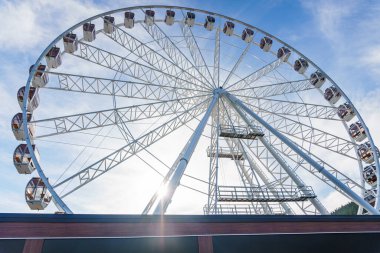 Bukovel 'de mavi gökyüzünün önünde büyük, uzun, beyaz dönme dolap. Karpatlar