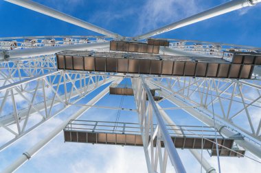 Bukovel 'de mavi gökyüzünün önünde büyük, uzun, beyaz dönme dolap. Karpatlar