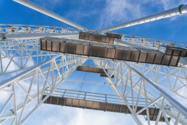 Bukovel 'de mavi gökyüzünün önünde büyük, uzun, beyaz dönme dolap. Karpatlar