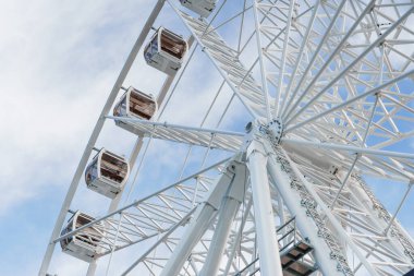 Bukovel 'de mavi gökyüzünün önünde büyük, uzun, beyaz dönme dolap. Karpatlar