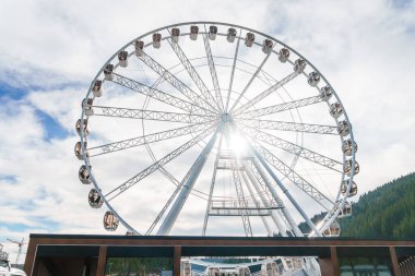 Bukovel 'de mavi gökyüzünün önünde büyük, uzun, beyaz dönme dolap. Karpatlar