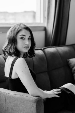 Kanepede oturan siyah elbiseli güzel kız.