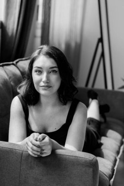 Kanepede oturan siyah elbiseli güzel kız.