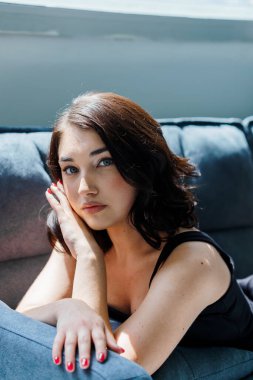 Kanepede oturan siyah elbiseli güzel kız.