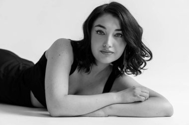 Gri arka planda siyah elbiseli güzel bir kızın portresi.