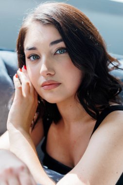 Gri arka planda siyah elbiseli güzel bir kızın portresi.