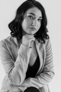 Siyah pantolonlu ve beyaz arka planda mavi ceketli güzel bir genç kız. Genç bir kadının portresi