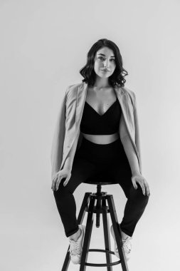 Siyah pantolonlu ve beyaz arka planda mavi ceketli güzel bir genç kız. Genç bir kadının portresi