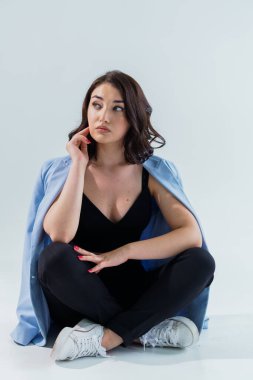 Siyah pantolonlu ve beyaz arka planda mavi ceketli güzel bir genç kız. Genç bir kadının portresi