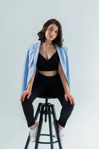 stock image Beautiful young girl in black trousers and a blue jacket on a white background. Portrait of a young woman