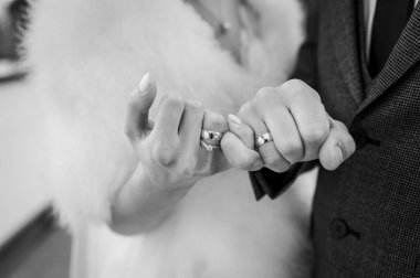 Yeni evlilerin ellerinde altın alyanslar.