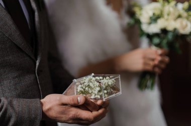 Elinde altın alyanslar olan bir kutu.