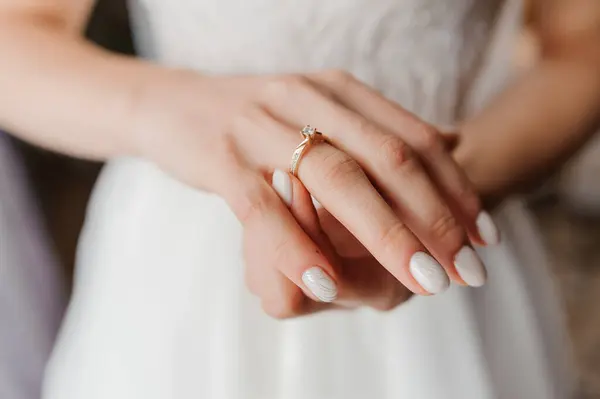 Gold ring with a diamond on a woman\'s hand