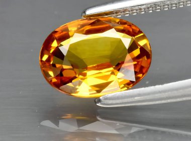 Arka planda doğal sarı safir taşı var.
