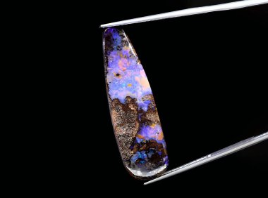 Arka planda doğal koyu renkli opal mücevher