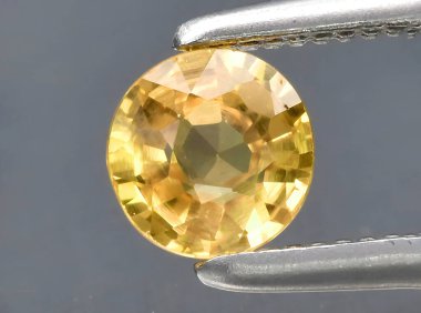 Arka planda doğal sarı safir taşı var.