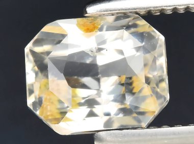 Arka planda doğal sarı safir taşı var.