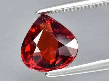 Arka planda doğal kırmızı spessartite taşı var.