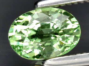 Arka planda doğal yeşil tsavorit taşından mücevher
