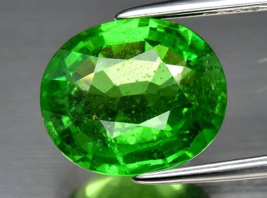 Arka planda doğal yeşil tsavorit taşından mücevher