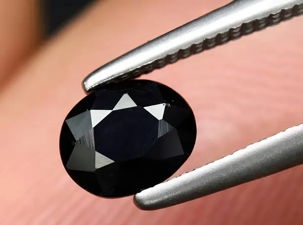 natural black sapphire gem on background