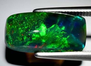 Arka planda doğal gökkuşağı çok renkli opal mücevher