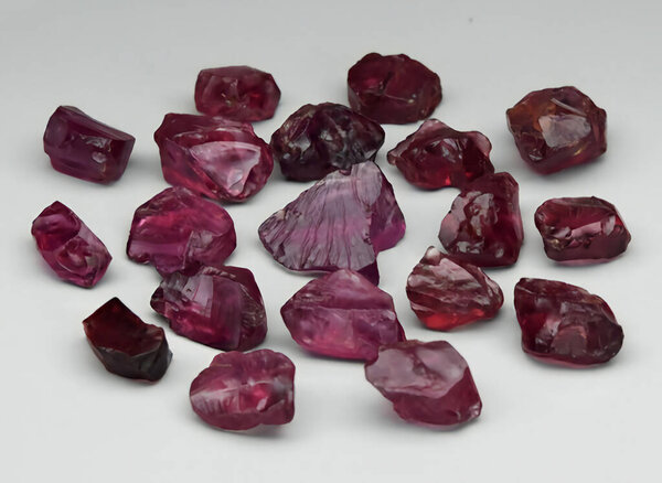 Natural pink rhodolite garnet rough gem on background