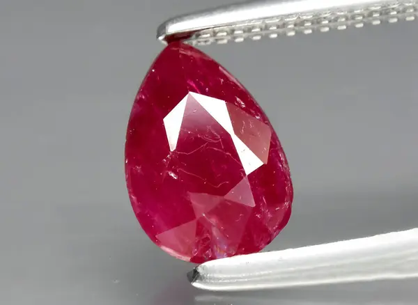 Natural red ruby gem on background