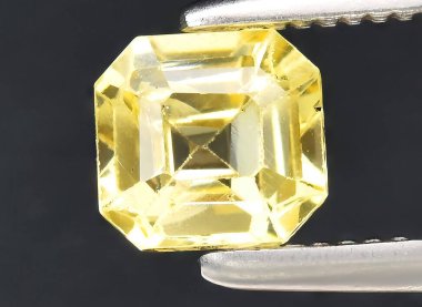 Arka planda doğal sarı safir taşı var.