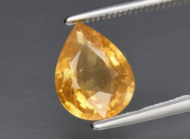 Arka planda doğal sarı safir taşı var.