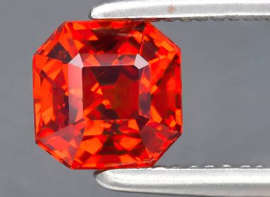 Arka planda doğal kırmızı spessartite taşı var.