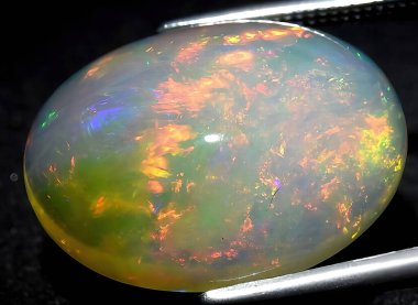 Arka planda doğal gökkuşağı çok renkli opal mücevher