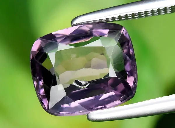 natural purple spinel gem on background