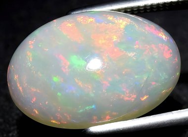 Arka planda doğal gökkuşağı opal mücevheri