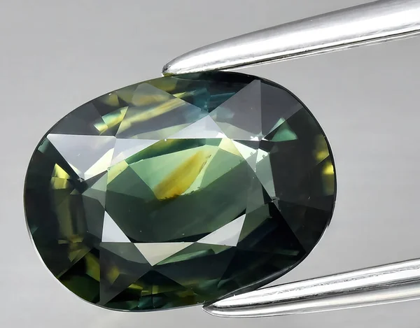 natural light green sapphire gem on background