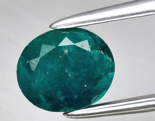 натуральный зеленый диоптазный камень на заднем плане