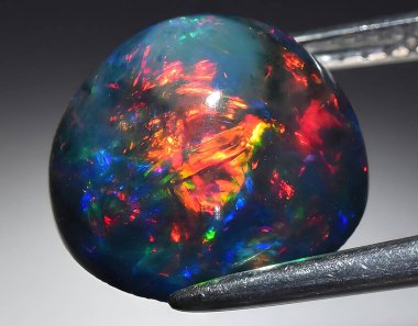 Arka planda doğal gökkuşağı çok renkli opal mücevher