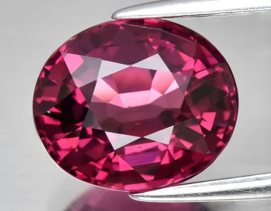 Arka planda doğal kırmızı mor rodolit taşlı mücevher.