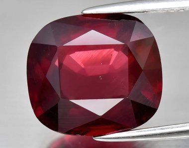 Arka planda doğal kırmızı mor rodolit taşlı mücevher.