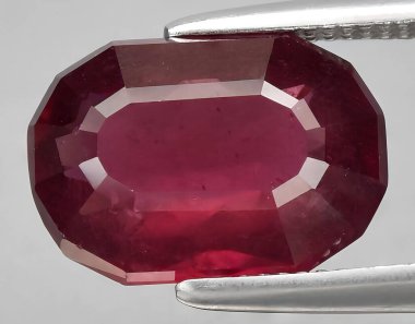 Arka planda doğal kırmızı mor rodolit taşlı mücevher.