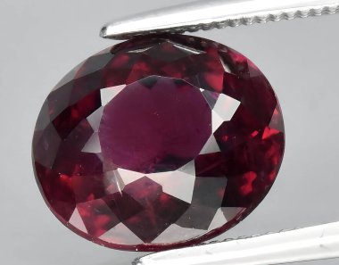 Arka planda doğal kırmızı mor rodolit taşlı mücevher.