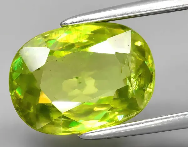 natural yellow green sphene gem on background