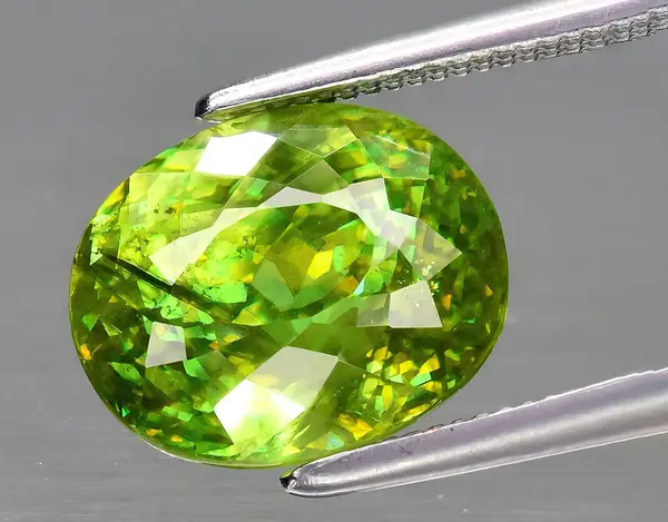 natural yellow green sphene gem on background