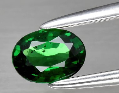 Arka planda doğal yeşil tsavorit taşından mücevher