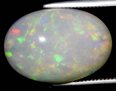 Arka planda doğal gökkuşağı çok renkli opal mücevher