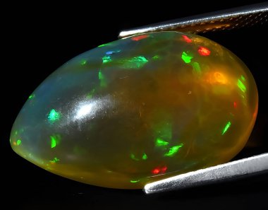 Arka planda doğal gökkuşağı çok renkli opal mücevher