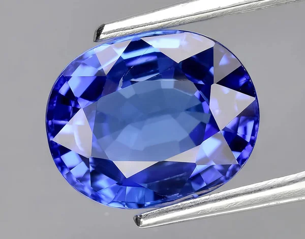 natural intense blue tanzanite gem on background