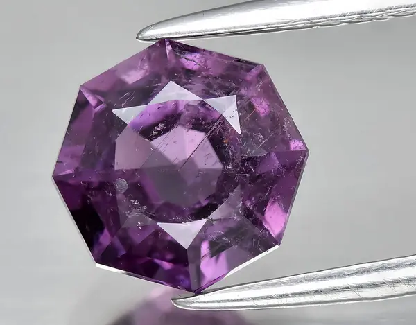 natural purple tourmaline gem on background