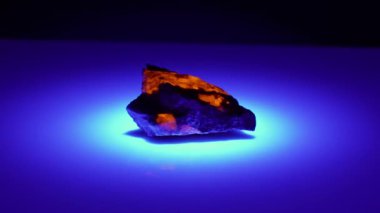 Arka planda ultraviyole ışıkta doğal yoopelit mücevheri