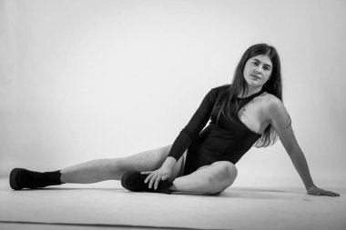 Beyaz bir arka planda siyah elbiseli güzel bir genç kız.